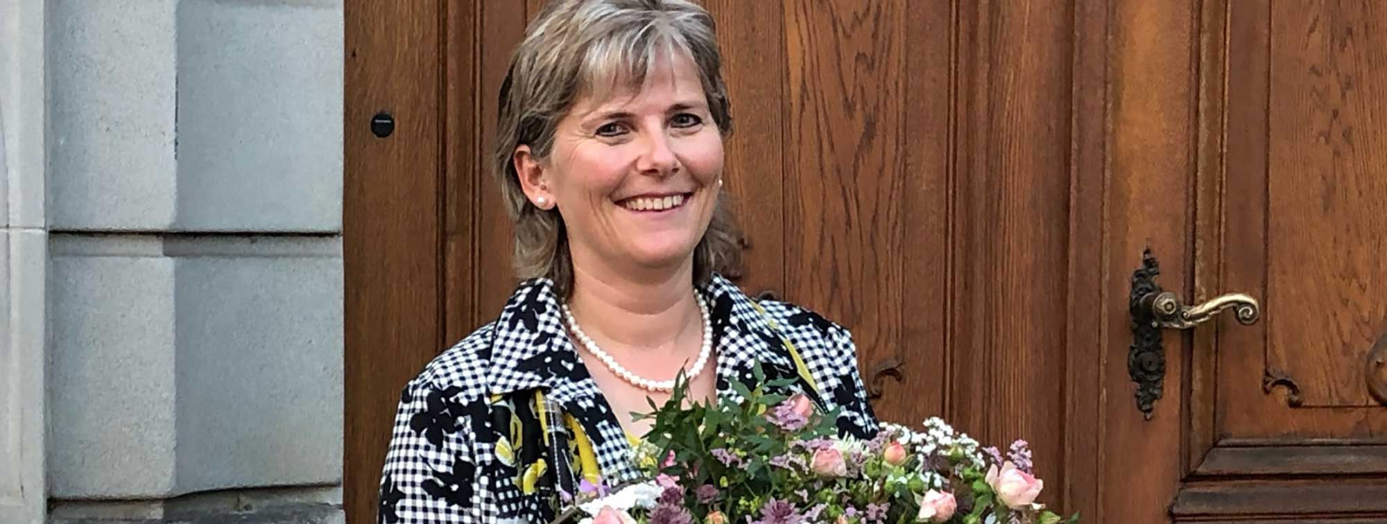Wahl zur ersten Stadtparlamentspräsidentin von Weinfelden Alexandra Beck mit Blumenstrauss vor Türe des Rathauses in Weinfelden